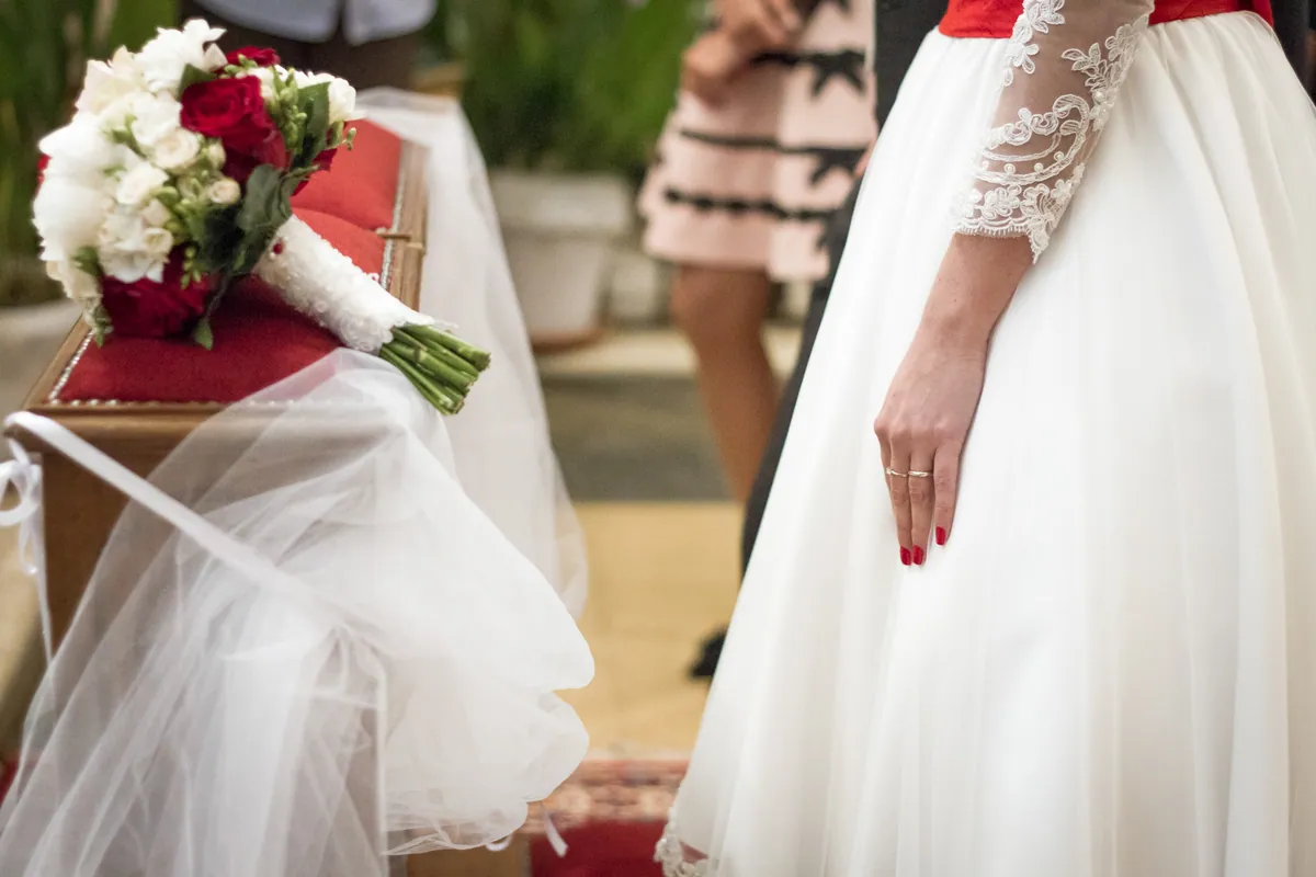 Sposa con bouquet di rose rosse
