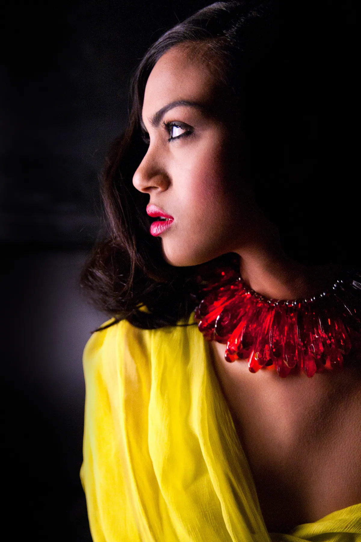 Profilo di modella con collana rossa e abito giallo