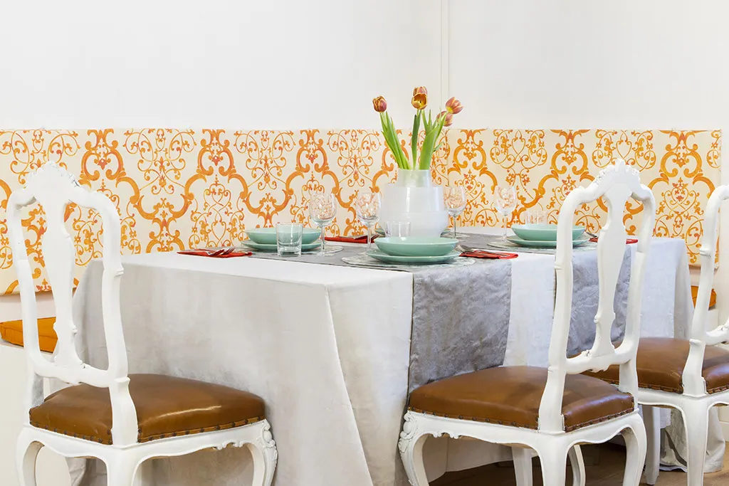 Tavolo da pranzo apparecchiato con sedie bianche e tulipani